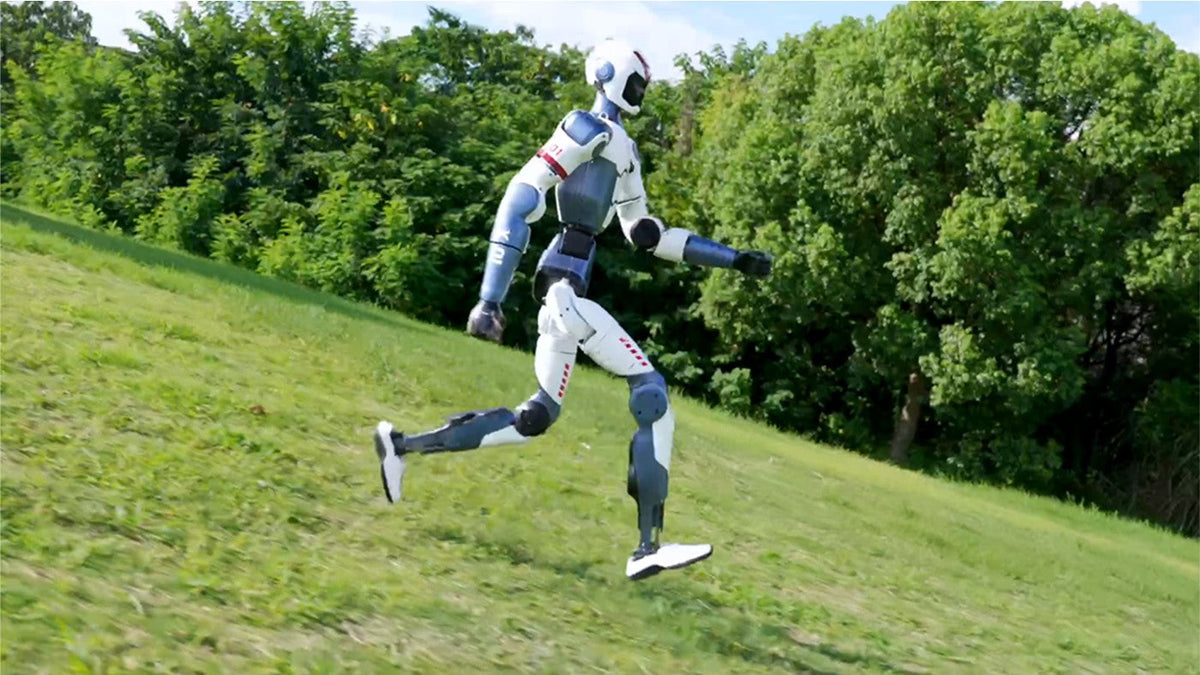 Unitree R1 running on a grassy slope